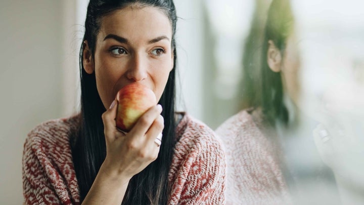 Frau beißt in Apfel